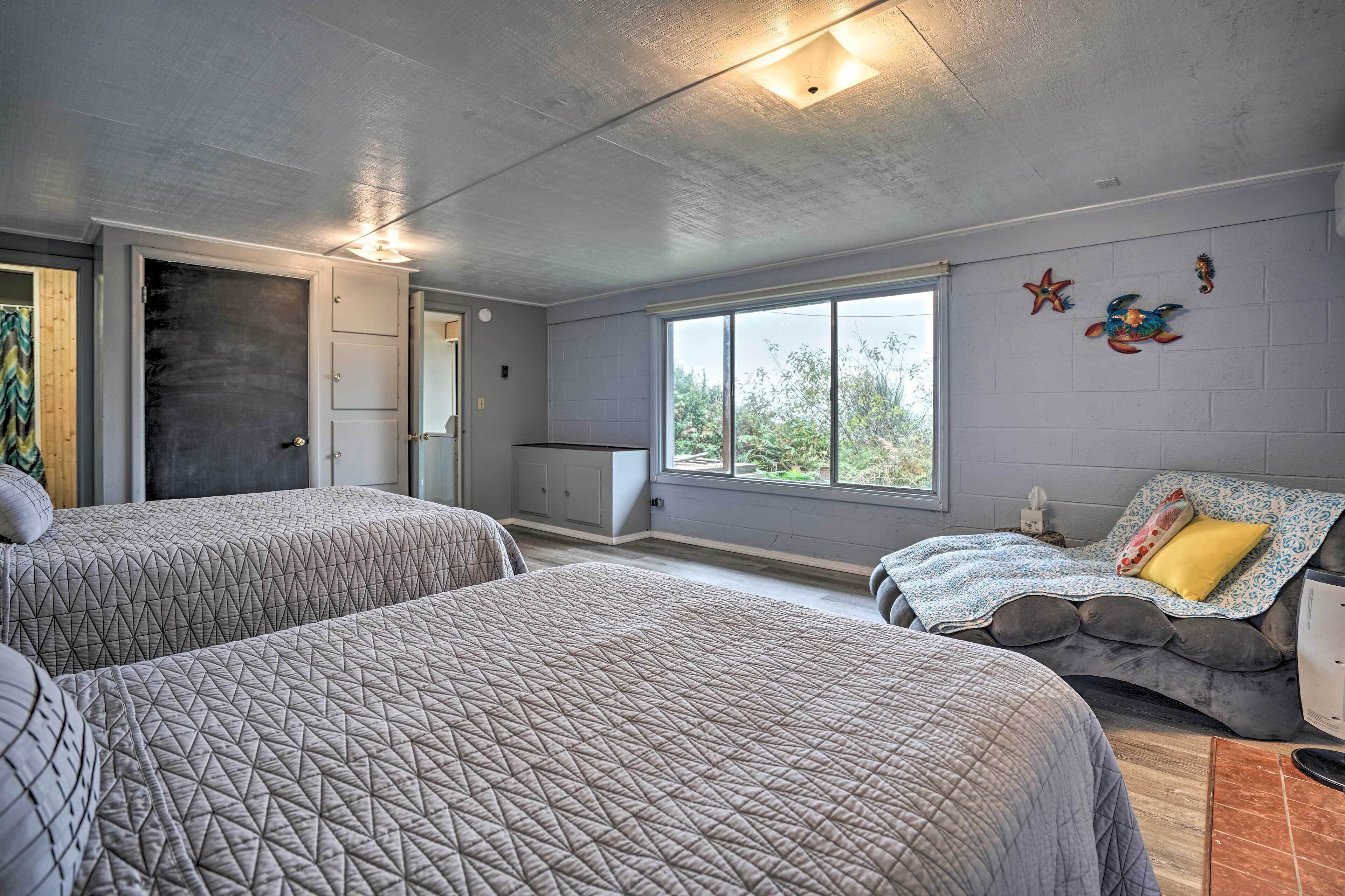 Un dormitorio con dos camas, un aparador, una ventana con vistas y una puerta.