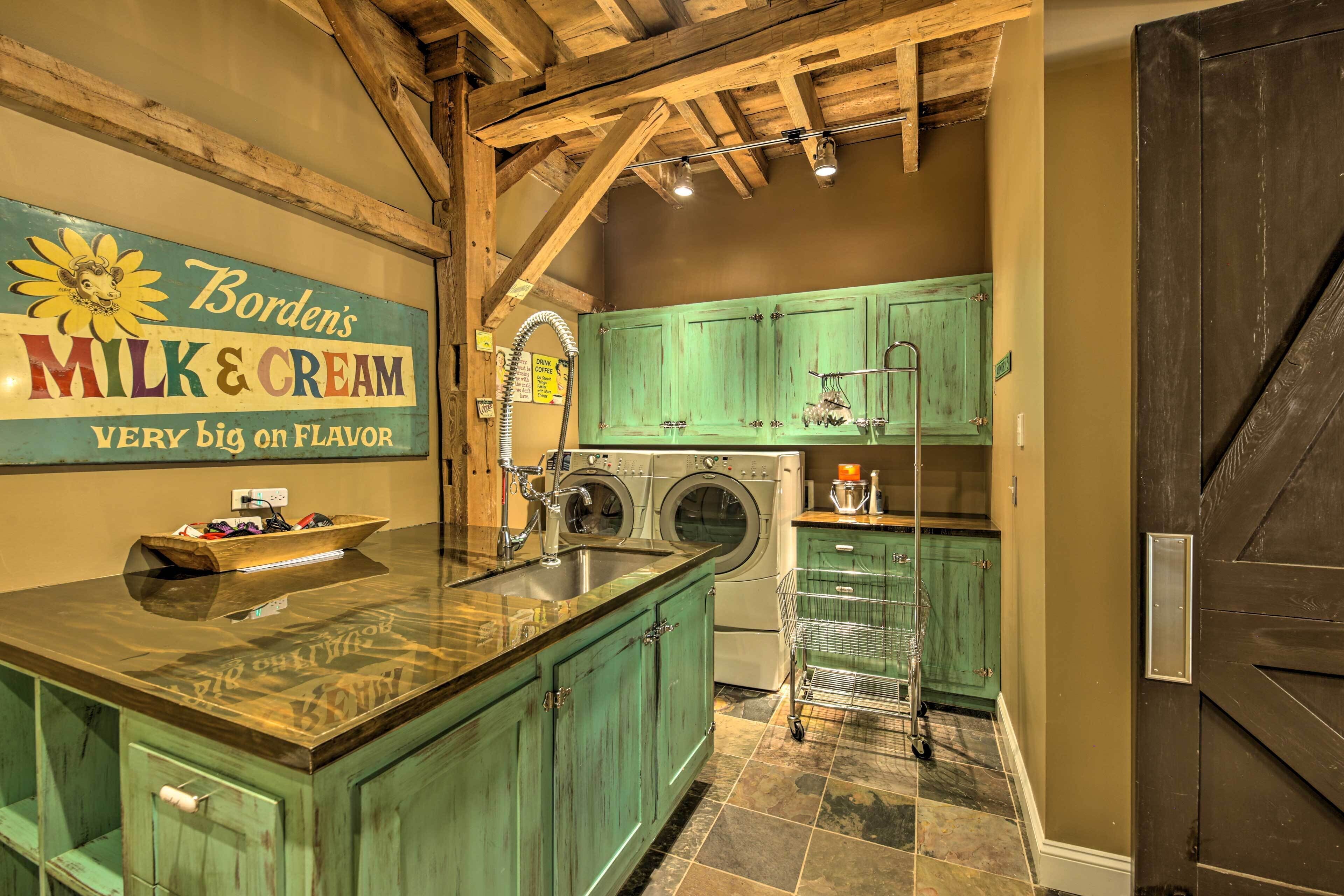 A kitchen with a large island, green cabinets, a sink, and a sign advertising Borden's Milk & Cream.