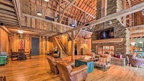 Un interior espacioso de madera con chimenea, sofás de cuero y un comedor.