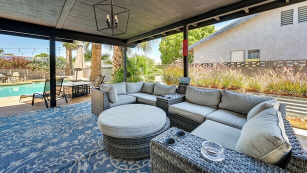 A covered outdoor seating area with a pool in the background. - Yuma Vacation Rental w/ Private Pool & Patio! (Yuma)