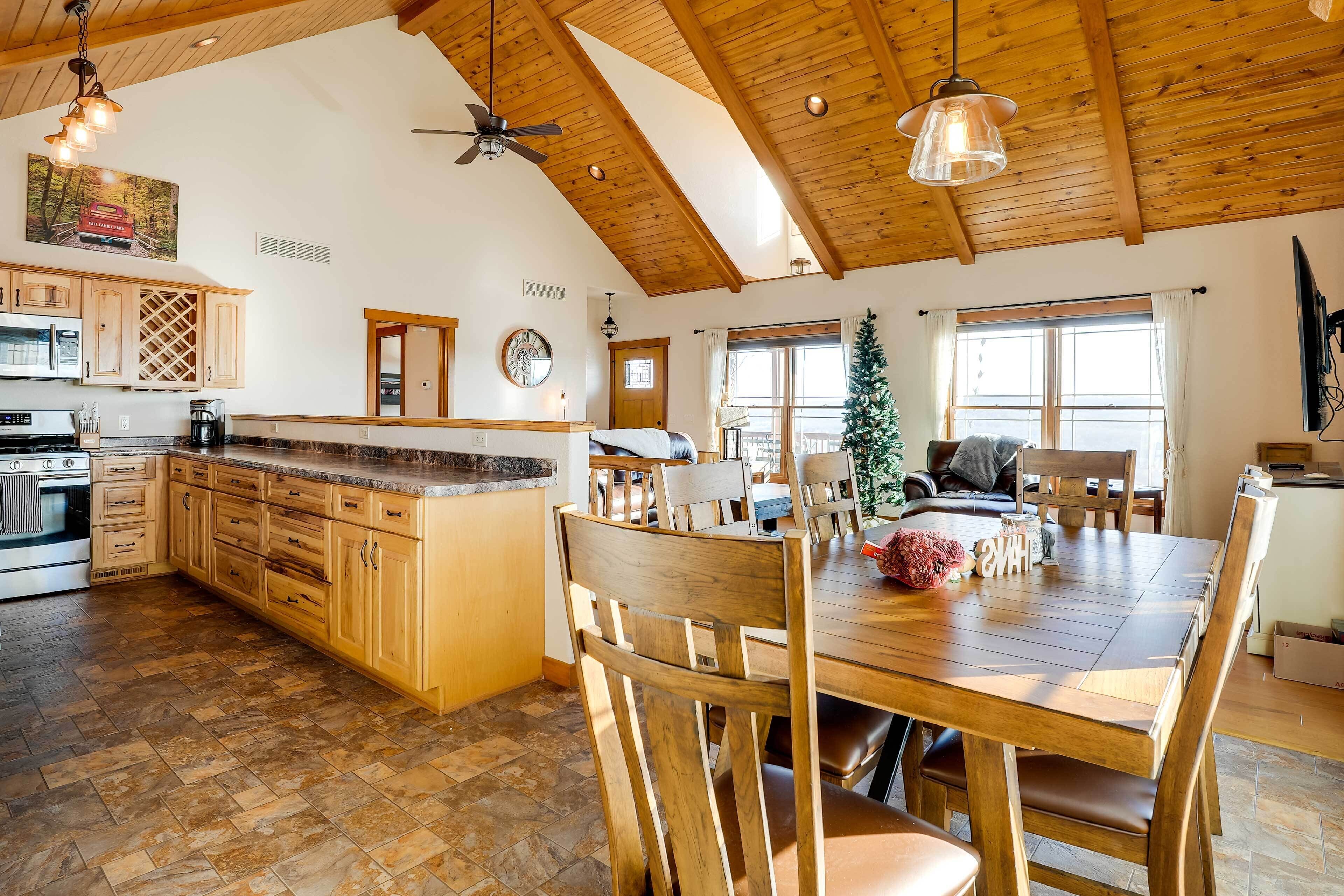 Una cocina amplia con armarios de madera, una isla grande y un comedor con sillas de madera.