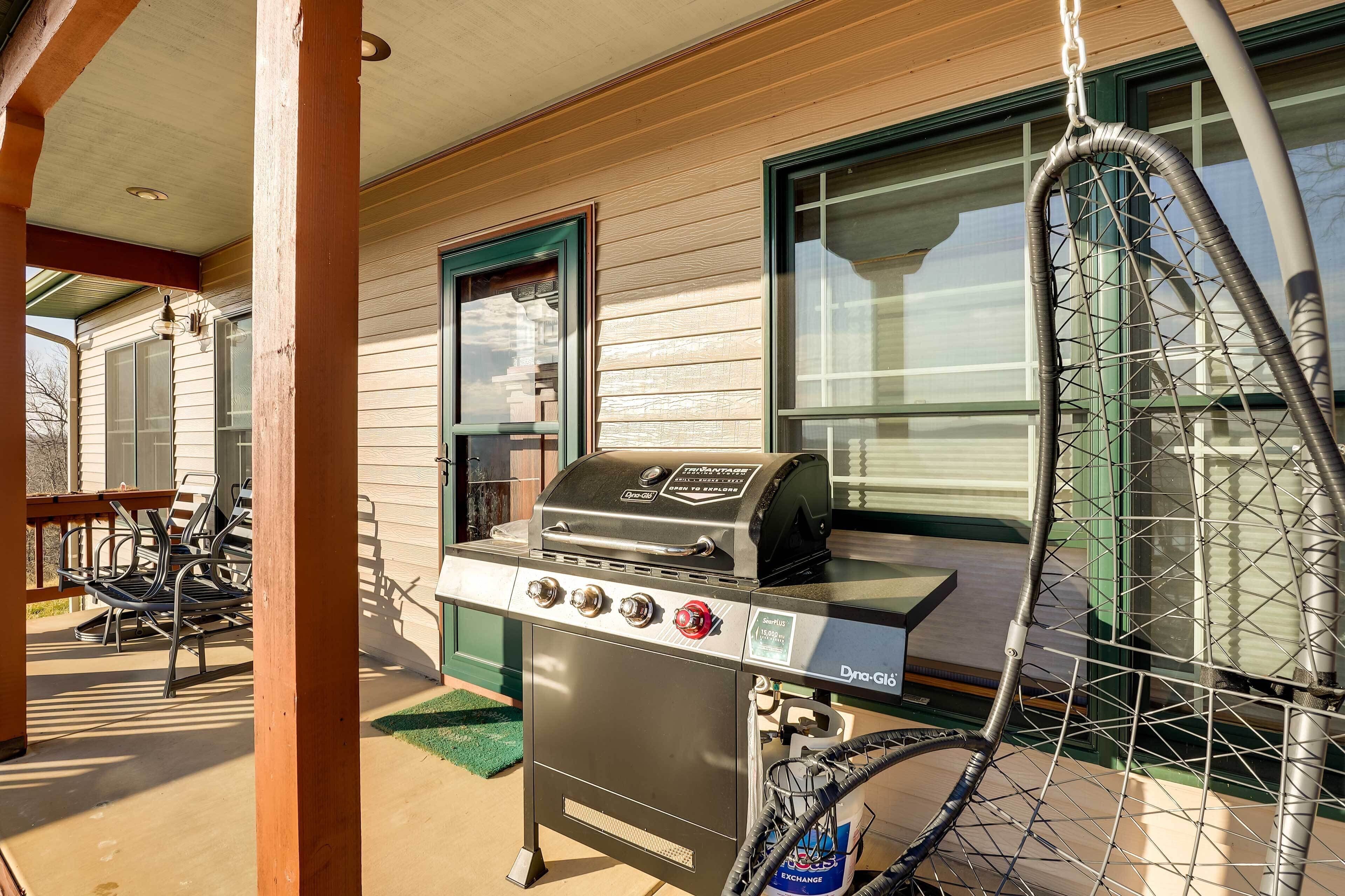 An outdoor grill area with a gas stove, a grill, and a hose.