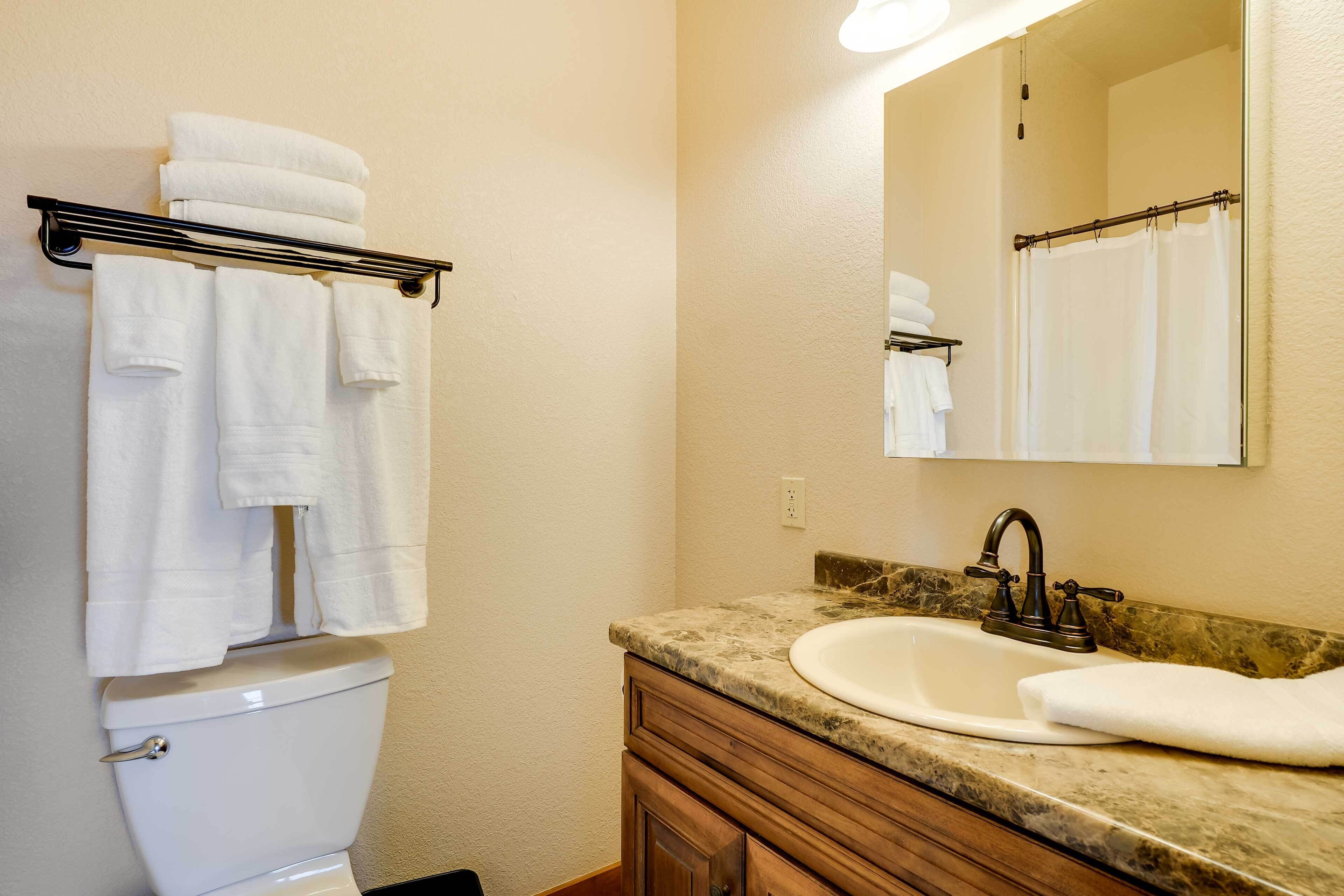 A bathroom with a toilet, a sink, and a towel rack.