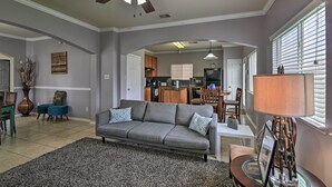 A living room with a gray sofa, a coffee table, and a ceiling fan.