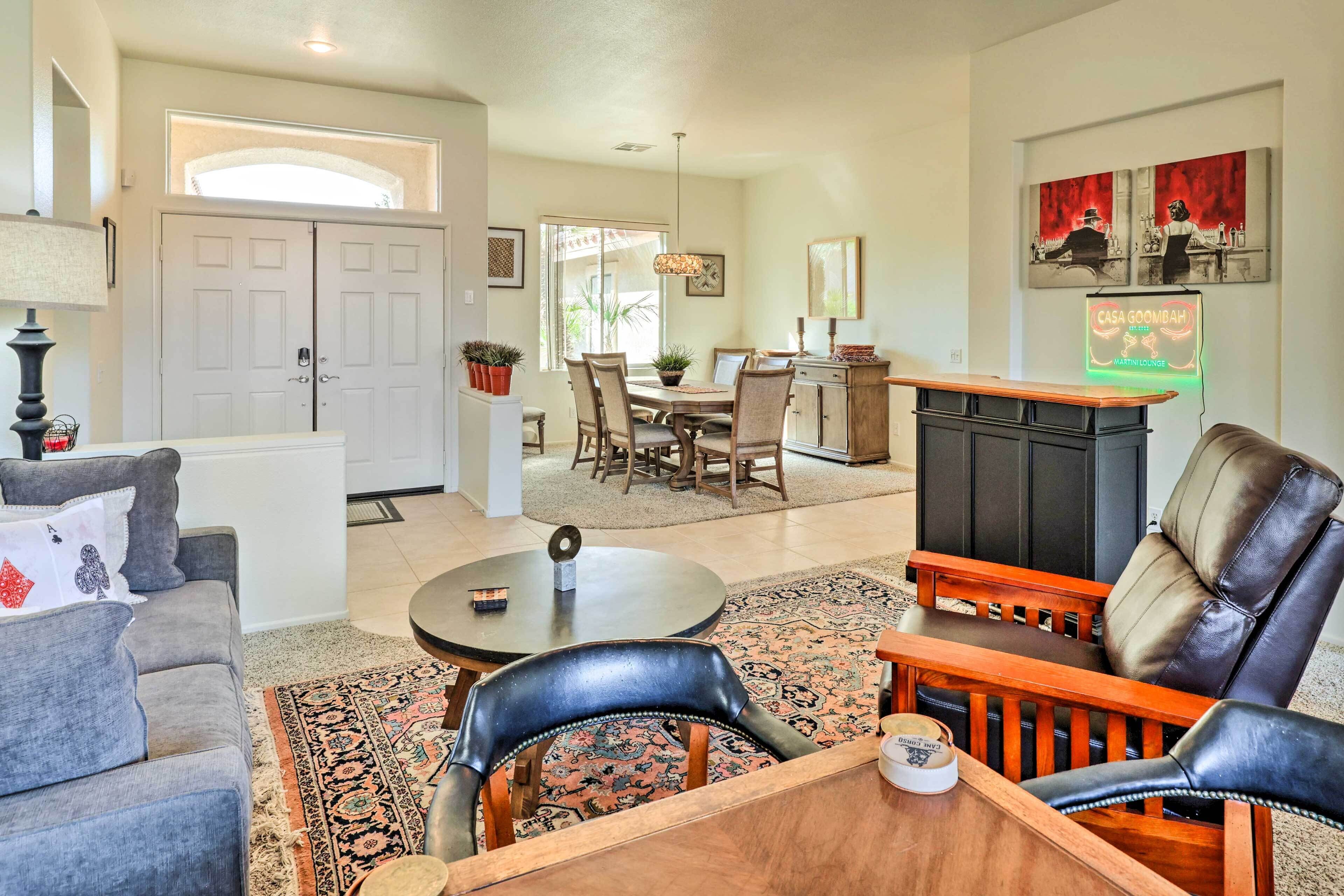 A living room with a fireplace, a dining area, and a kitchen in the background.