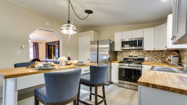 A modern kitchen with a wooden island, stainless steel appliances, and a tiled backsplash. - Walk to Lake! All-season Retreat in Poconos Mtns (Greentown)