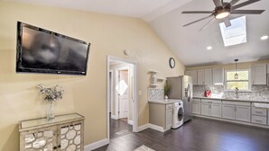 A kitchen with a ceiling fan, a TV mounted on the wall, and a washing machine. - Bay Area Vacation Rental 4 Mi to Stanford! (Redwood City)