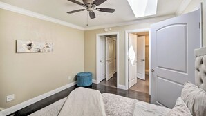 A bedroom with a bed, a ceiling fan, a skylight, and a door leading to another room. - Bay Area Vacation Rental 4 Mi to Stanford! (Redwood City)