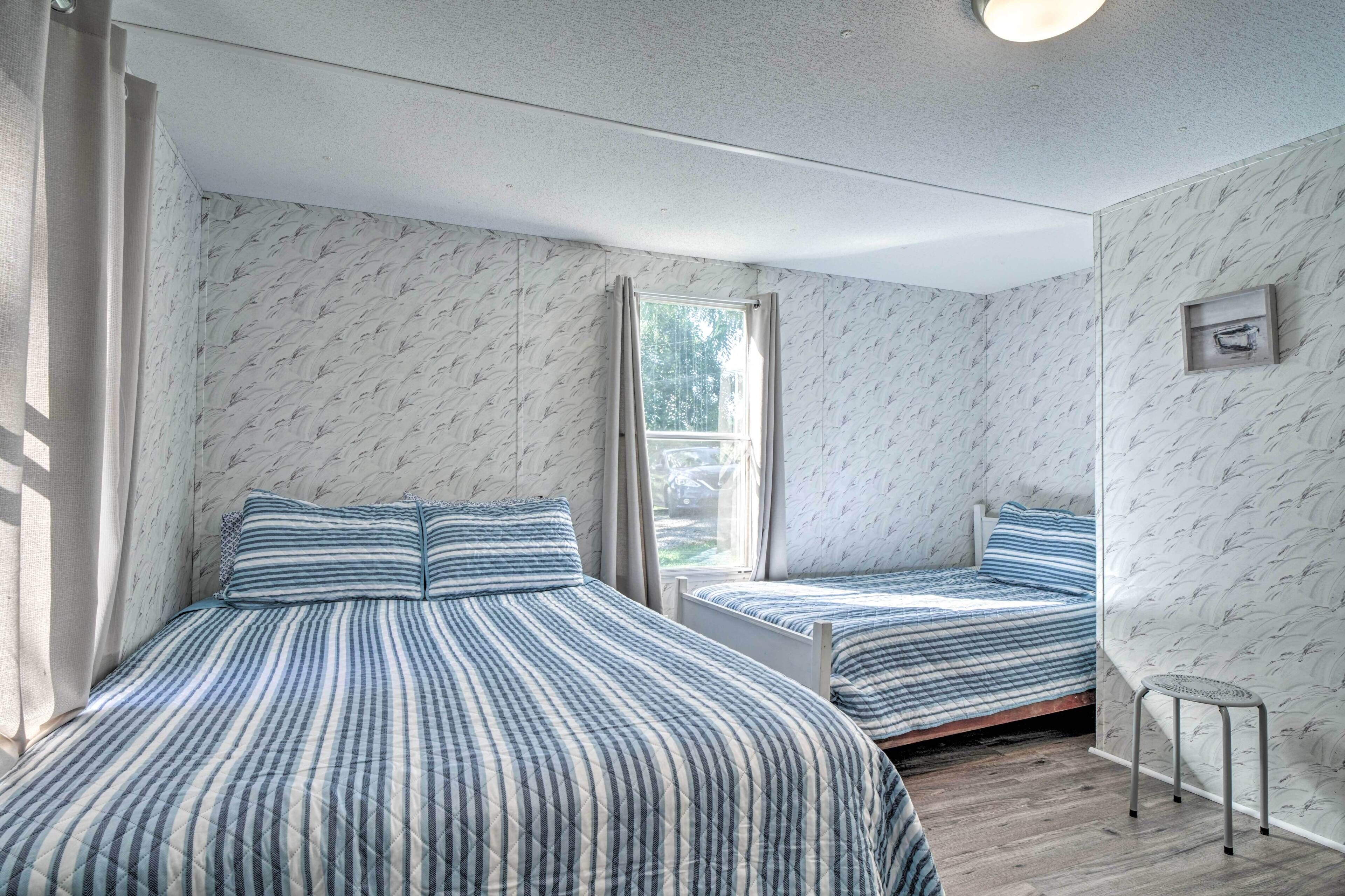 Een kamer met twee bedden, een raam en een klein tafeltje.