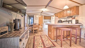 A kitchen with wooden cabinets, a built-in stove, and a bar area. - Quaint Cottage Overlooking Cherokee Reservoir (Bean Station)