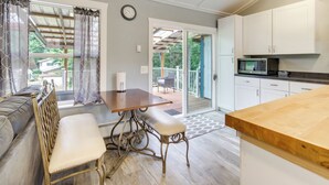 A modern kitchen with white cabinets, a wooden countertop, and a built-in microwave. - Cozy North Bend Getaway Near Dunes + Ocean! (North Bend)