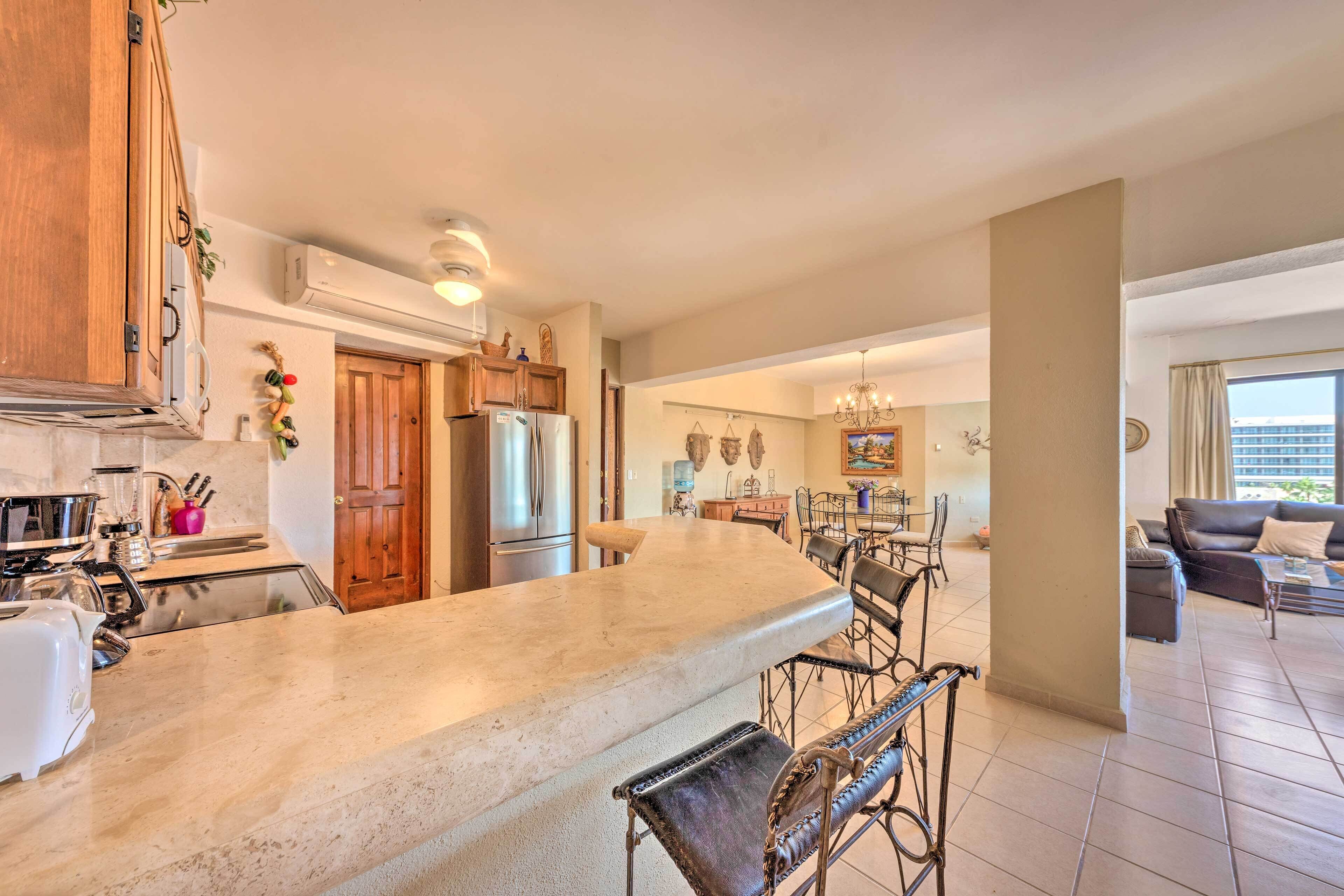 A spacious kitchen with a large island, wooden cabinets, and modern appliances.