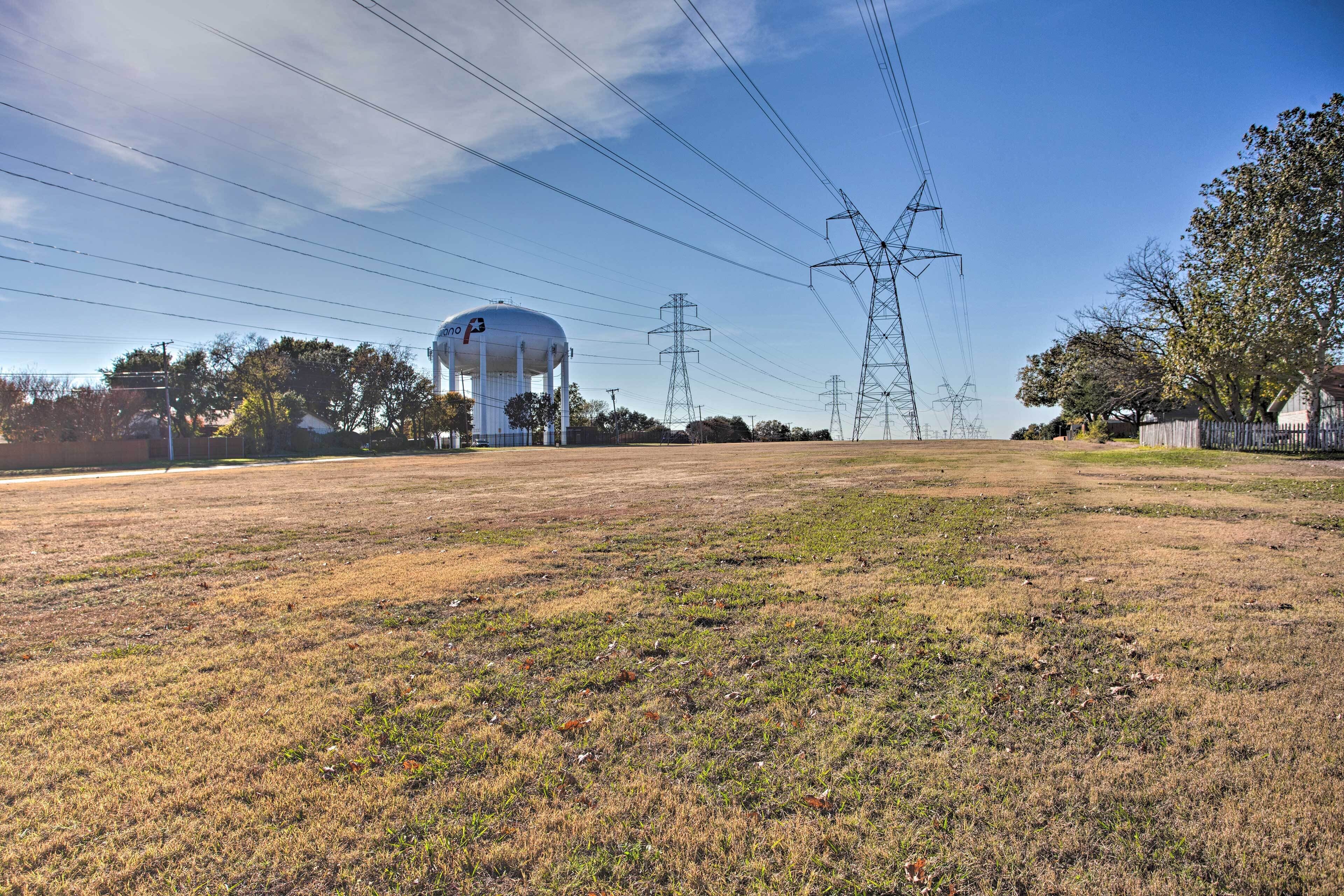 A large water tower and power lines in a rural setting.