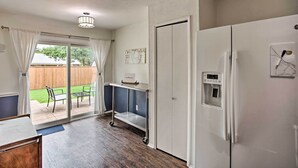 A kitchen with a refrigerator, a water dispenser, and a cart.