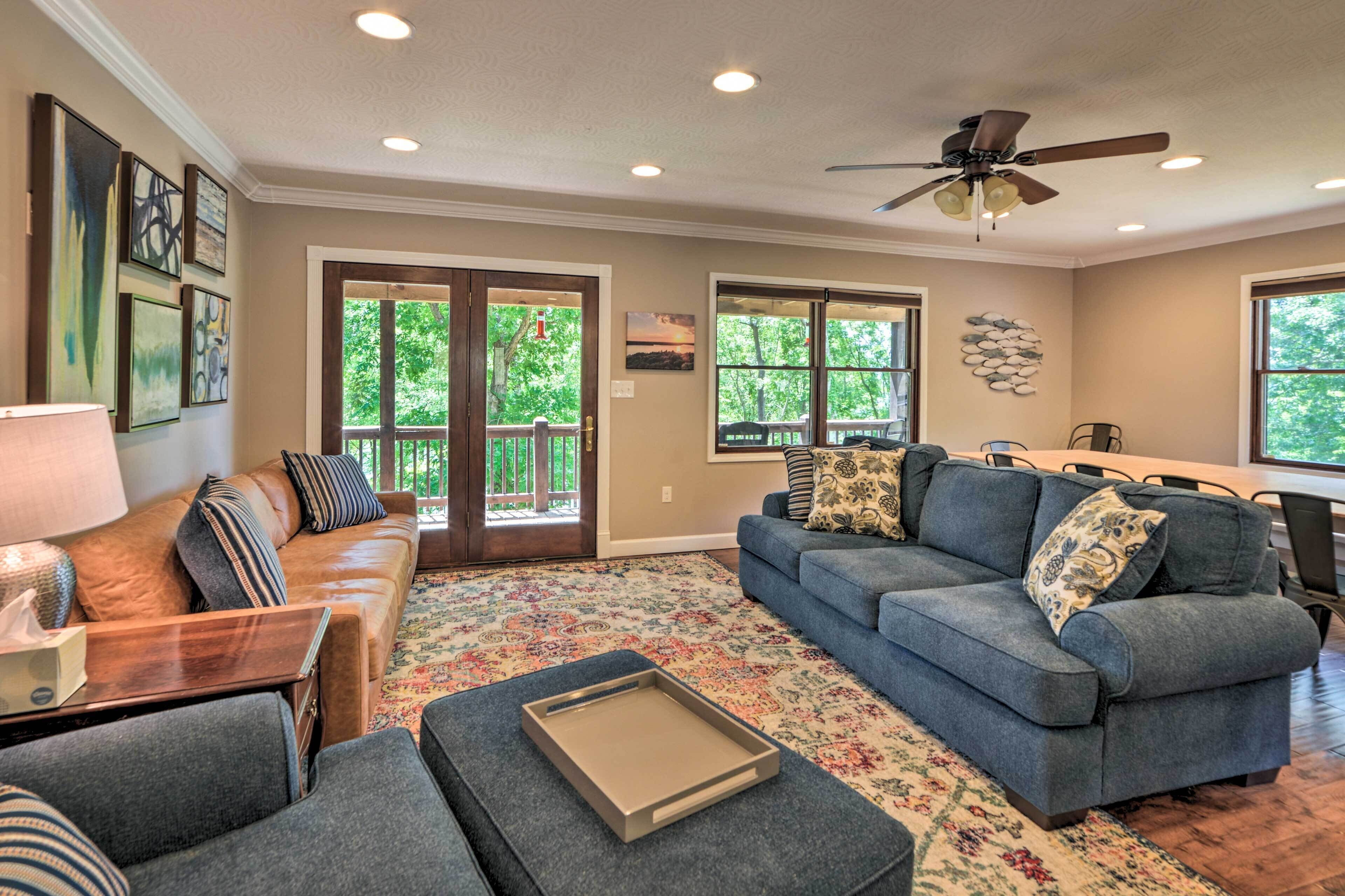 A spacious living room with a large sofa, a coffee table, and a dining area with a table and chairs.