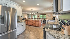 A modern kitchen with stainless steel appliances, a granite countertop, and a central island. - Lakefront 'rest-ashored' Home w/ Private Dock! (Eddyville)