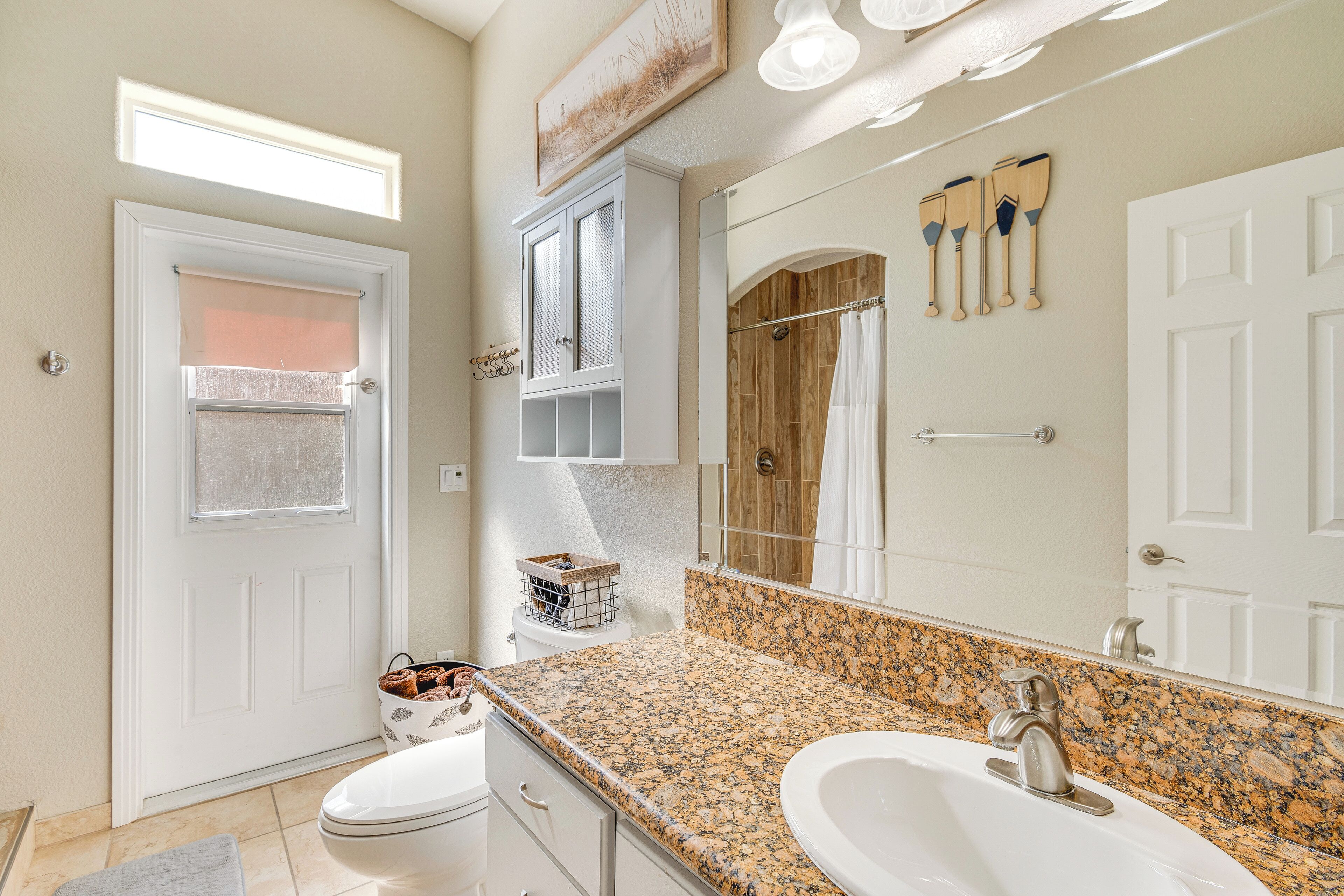 A bathroom with a double sink, a large mirror, and a shower area.