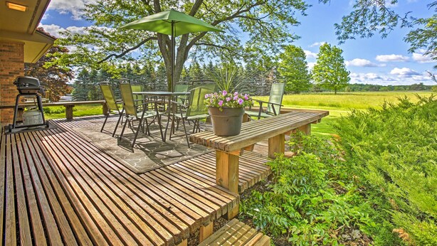 A wooden deck with outdoor furniture, a grill, and a potted plant. - 3 Mi to Silver Lake: Traverse City Home w/ Deck (Traverse City)