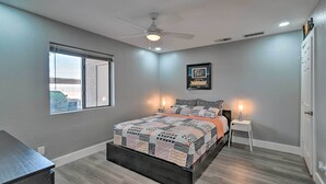 A bedroom with a bed, a ceiling fan, a window, and a door. - Peaceful Apache Junction Condo ~ 1 Mi to Downtown! (Apache Junction)