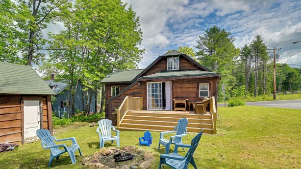 Un chalet rustique doté d’une véranda, d’un espace salon extérieur et d’un foyer.