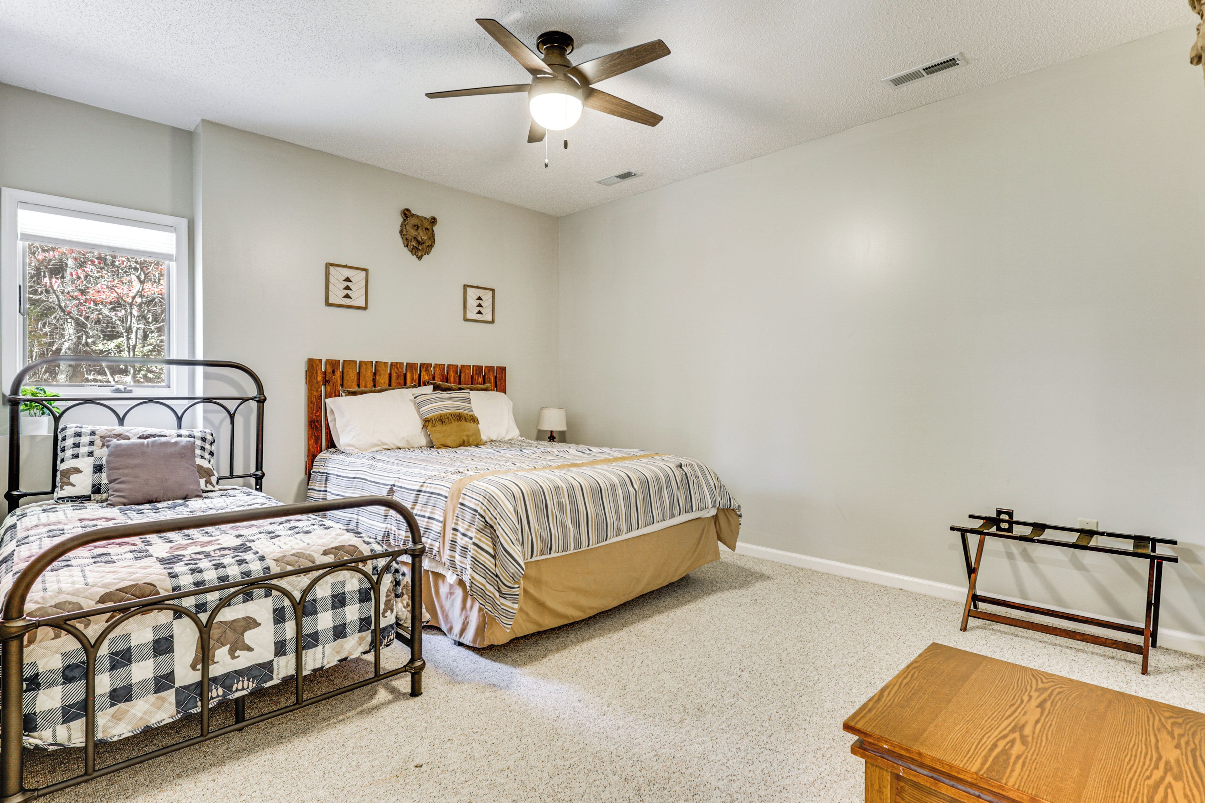 A bedroom with a bed, a desk, and a ceiling fan.
