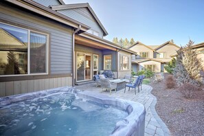 Un quartier résidentiel doté d’un jacuzzi, de meubles de jardin et d’une maison avec un garage.