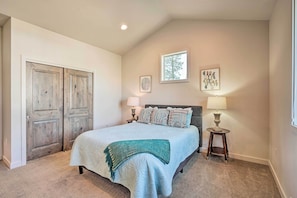 A bedroom with a bed, two bedside tables, a window, and a door. - Luxury Mt Bachelor Retreat w/ Hot Tub & Patio (Bend)
