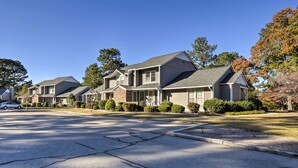 A row of modern two-story houses with a driveway and a street. - Modern Townhome w/ Deck & Golf Course Views! (Pinehurst)