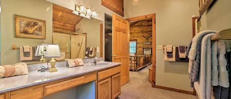 A bathroom with wooden cabinets, a large mirror, and a sink.