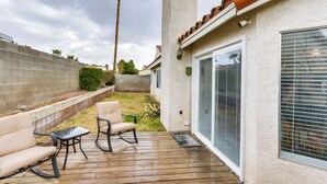 A patio with outdoor furniture, a wooden deck, and a view of a house with a screened porch and a window with blinds. - Pet-friendly Escape w/ Grill, 11 Mi to Strip! (North Las Vegas)