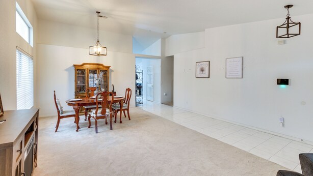 A spacious living area with a dining table and chairs, a wooden cabinet, and a chandelier. - Pet-friendly Escape w/ Grill, 11 Mi to Strip! (North Las Vegas)