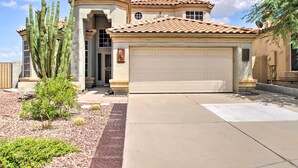 A house with a garage, a large cactus, and a small tree. - Goodyear Home w/ Pool, Quiet Walkable Community (Goodyear)