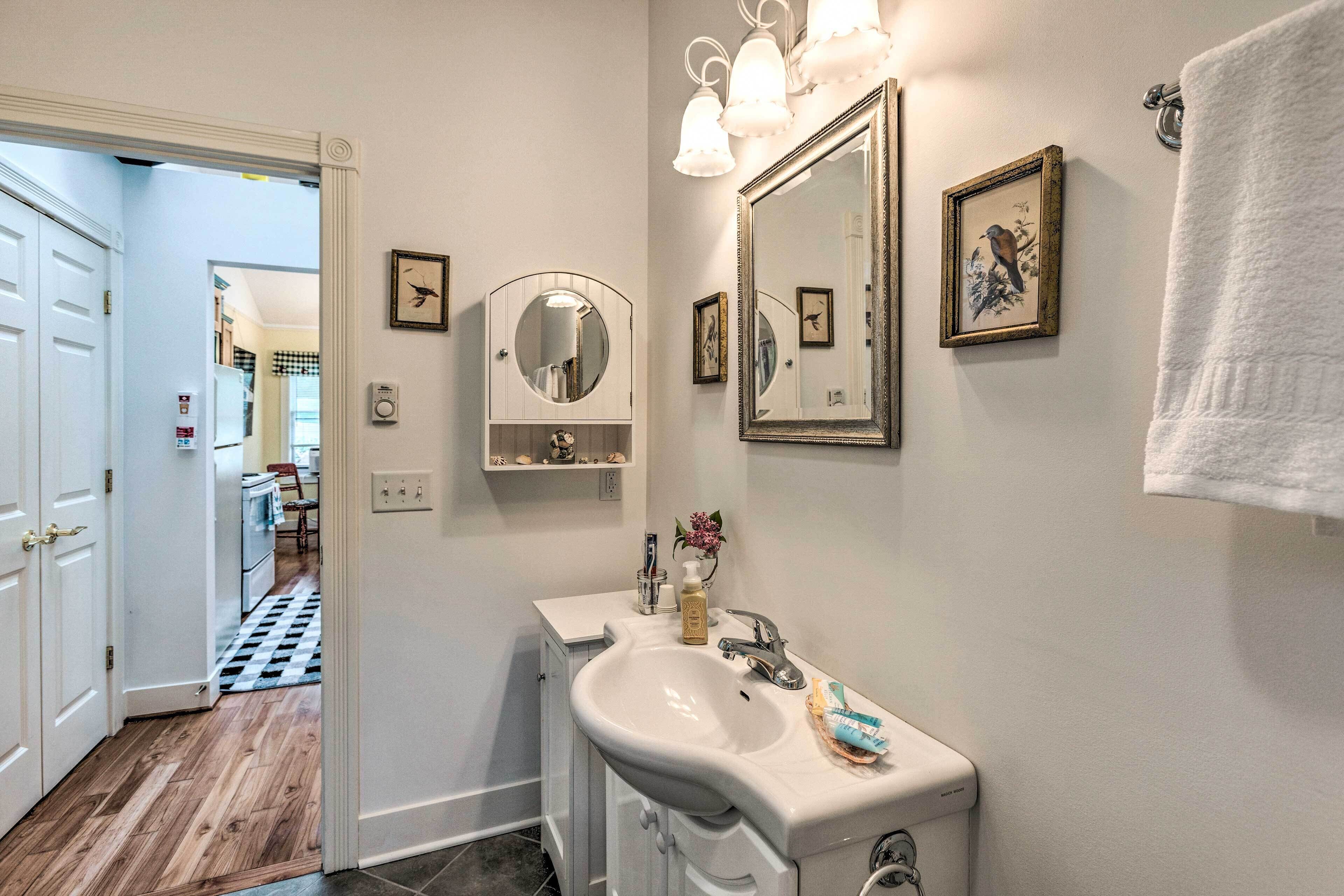A bathroom with a sink, mirror, and towel rack.
