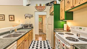 A kitchen with a checkered floor, a refrigerator, a stove, and a microwave. - 18 Mi to Crystal Mtn: Couple's Haven Near Lake (Frankfort)
