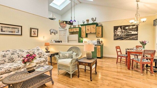 A spacious living area with a sofa, wicker chairs, a dining table, and a kitchen area with wooden cabinets and a refrigerator. - 18 Mi to Crystal Mtn: Couple's Haven Near Lake (Frankfort)