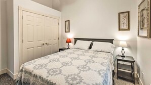 A bedroom with a bed, two bedside tables with lamps, a wardrobe, and framed pictures on the walls. - 18 Mi to Crystal Mtn: Couple's Haven Near Lake (Frankfort)
