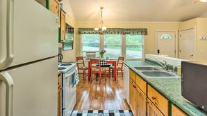 A kitchen with a dining table, chairs, a refrigerator, stove, and a window with blinds. - 18 Mi to Crystal Mtn: Couple's Haven Near Lake (Frankfort)