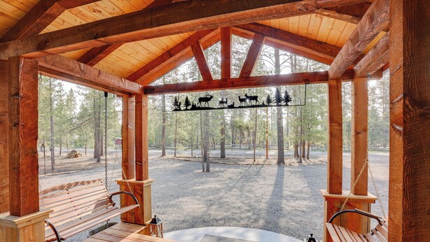 Un gazebo in legno con panche e un cartello raffigurante animali.