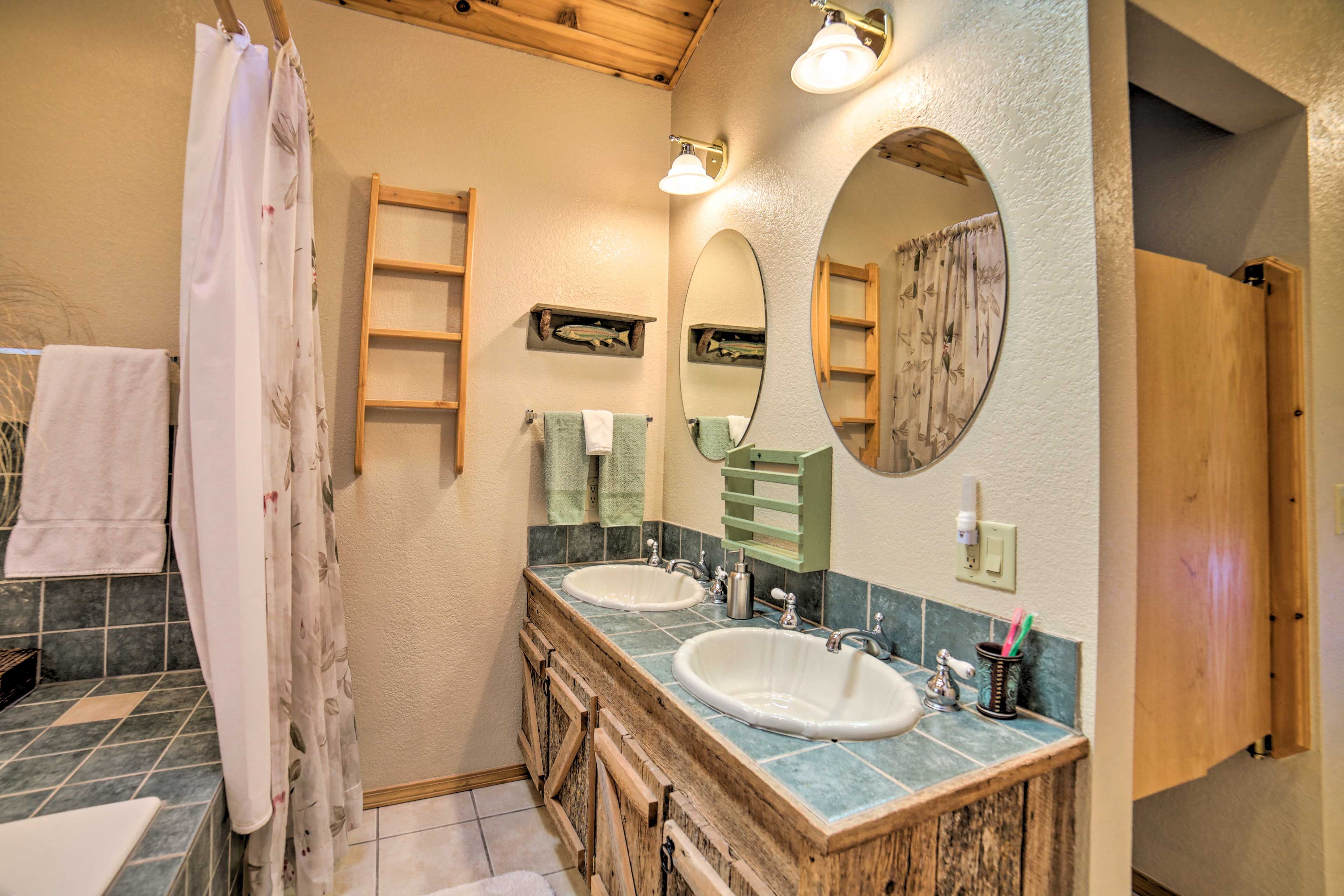 A bathroom with two sinks, a mirror, and a shower curtain.