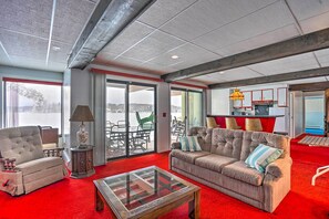 Relax in this inviting living area with a plush sofa, armchair, and glass coffee table.