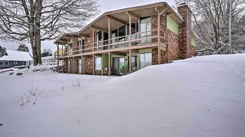 A two-story building with a balcony, surrounded by snow.