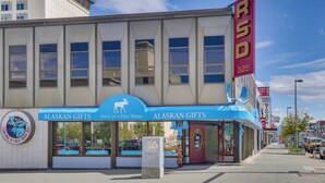 Una fachada comercial con un toldo azul que dice 'Alaskan Gifts' y un letrero que indica 'RSD 325'.