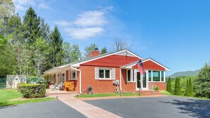 Een gelijkvloers bakstenen huis met een rood dak, een voortuin en een garage.