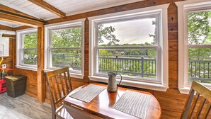 A wooden interior with large windows, a table with a pitcher, and a chair. - Our Lakeside Retreat w/ Deck on Lake Herrington! (Lancaster)