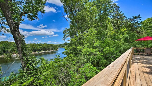 A wooden deck overlooking a river, surrounded by dense greenery. - Our Lakeside Retreat w/ Deck on Lake Herrington! (Lancaster)