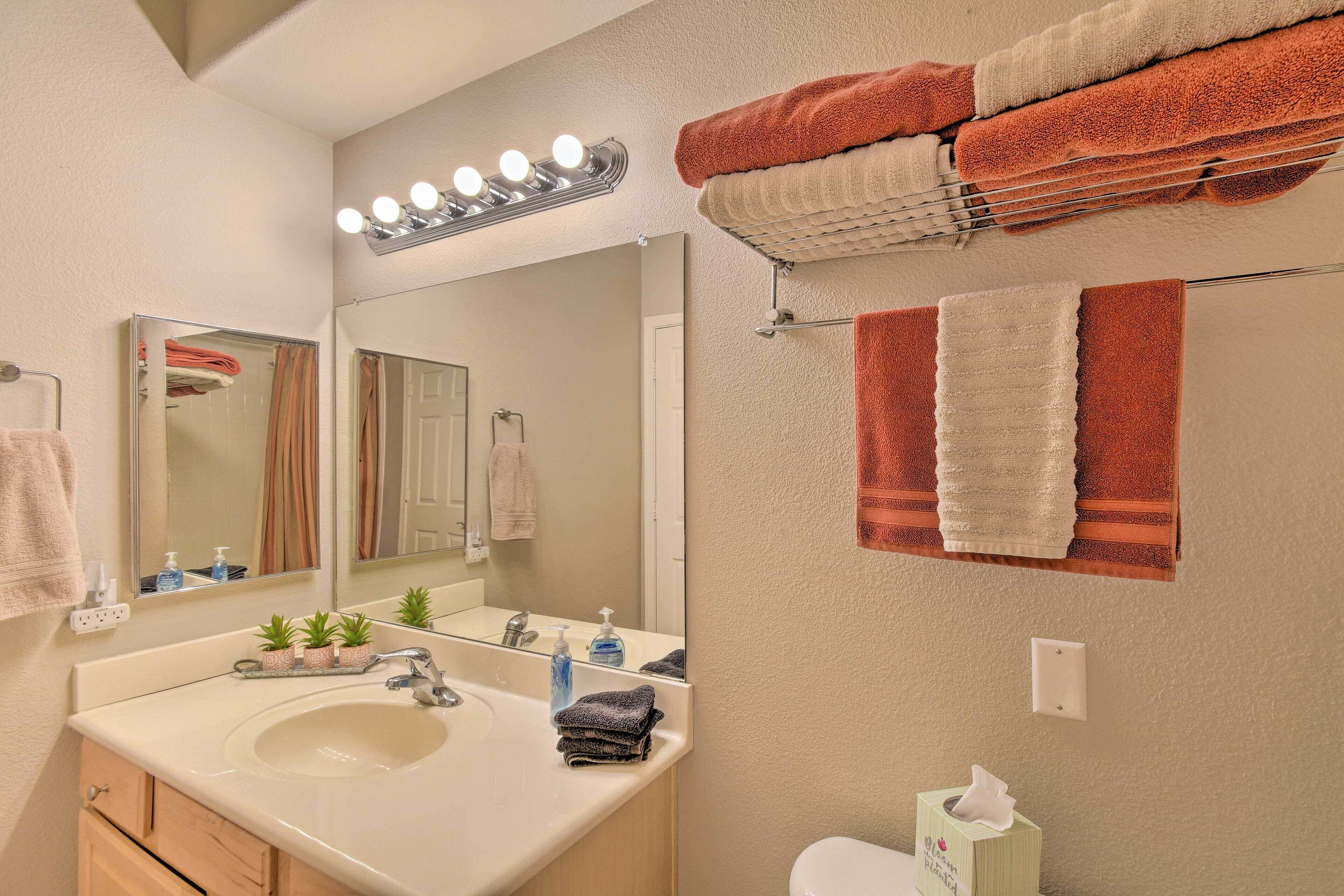 A bathroom with a sink, mirror, and towel rack.