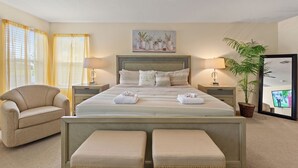 A bedroom with a bed, two bedside tables, a chair, a ceiling fan, a potted plant, and a painting on the wall. - Greenview Bliss By Shine Villas #031 5 Bedroom Villa (Davenport)