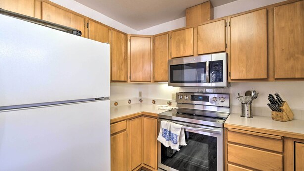 A kitchen with wooden cabinets, a white refrigerator, a stainless steel oven, and a microwave. - Pet-friendly Ocean Park Home w/ Decks & View! (Ocean Park)