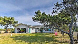A single-story house with a garage, a small porch, and a grassy yard. - Pet-friendly Ocean Park Home w/ Decks & View! (Ocean Park)