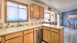 A kitchen with wooden cabinets, a dishwasher, and a window with blinds. - Pet-friendly Ocean Park Home w/ Decks & View! (Ocean Park)